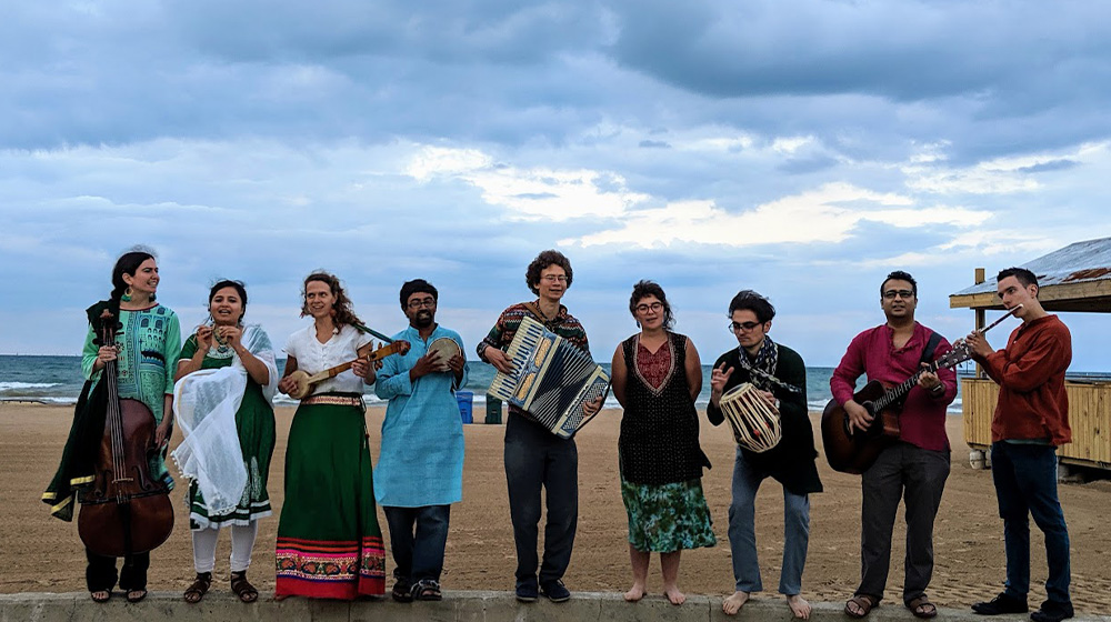 Members of the band, Ochin Pakhi, stand on the beach.